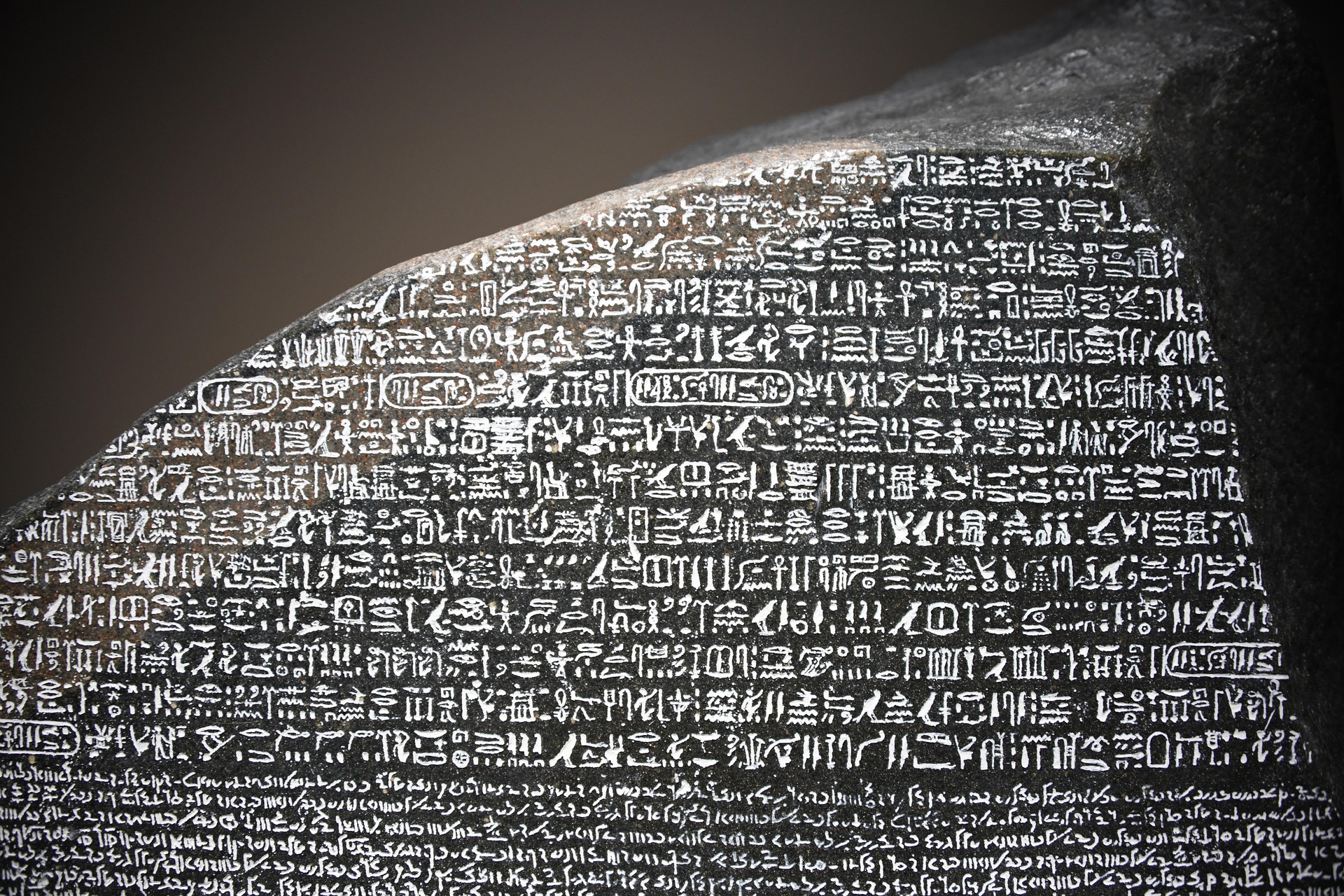 Detail of the Rosetta Stone (196 BC) inscribed with text in Ancient Egyptian (in hyeroglyphic and Demotic script) and Ancient Greek.